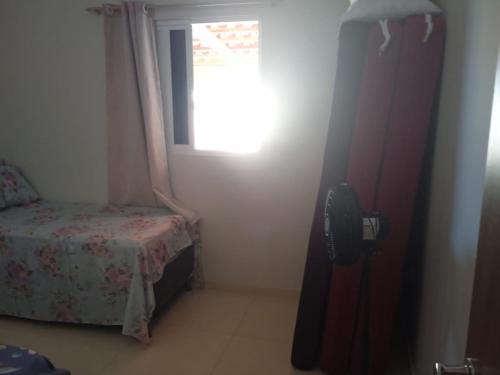 a small bedroom with a bed and a window at Casa do Descanso in Triunfo