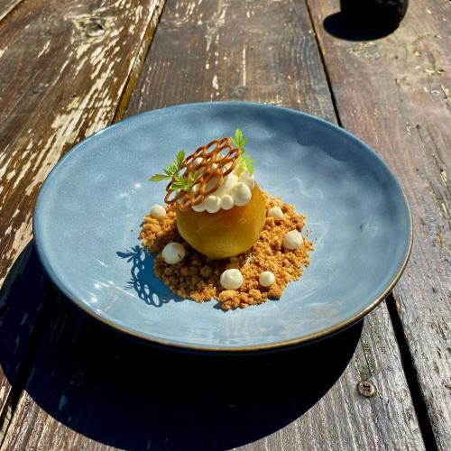 a dessert on a blue plate on a wooden table at Auberge du Relais d'Auniac - Hôtel Bar Restaurant Piscine in Anglars-Nozac