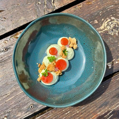 a blue plate with eggs and tomatoes on a table at Auberge du Relais d'Auniac - Hôtel Bar Restaurant Piscine in Anglars-Nozac