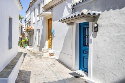 a blue door on the side of a white building at Campanile Seaview Serenity in Skopelos Town