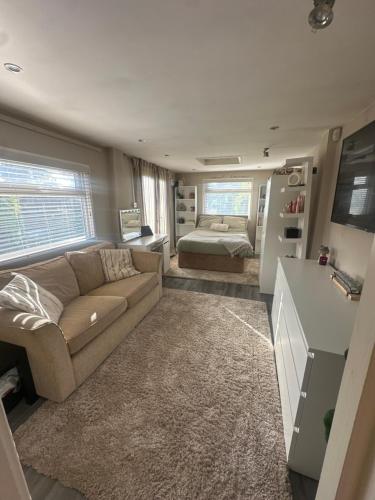 una sala de estar con un sofá y una cama en Birkdale Golf Open Holiday Home, en Southport