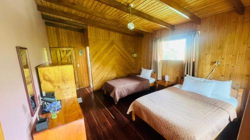 a hotel room with two beds and a window at El Toucanet Lodge & Restaurante in El Copey