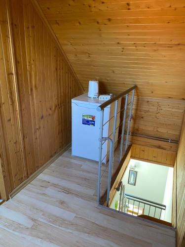 a staircase in a wooden room with a refrigerator at DorJan - Pokoje Gościnne in Dziwnówek