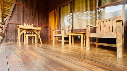 a room with wooden tables and benches in a cabin at El Toucanet Lodge & Restaurante in El Copey