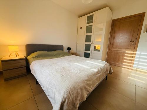 a bedroom with a bed and a lamp on a night stand at Gîte Le 3 in Gesves