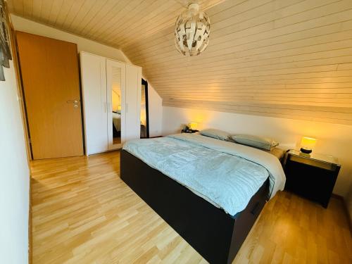 a bedroom with a bed and a chandelier at Gîte Le 3 in Gesves