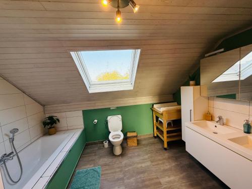 Un baño con inodoro, lavabo y ventana. en Gîte Le 3, en Gesves