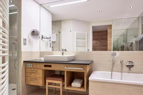 a bathroom with a sink and a bath tub and a sink at Familienresort Buchau in Maurach