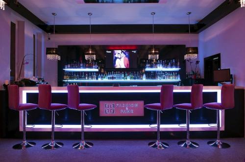 bar z czerwonymi krzesłami i telewizorem w pokoju w obiekcie Hotel Vega w mieście Lębork