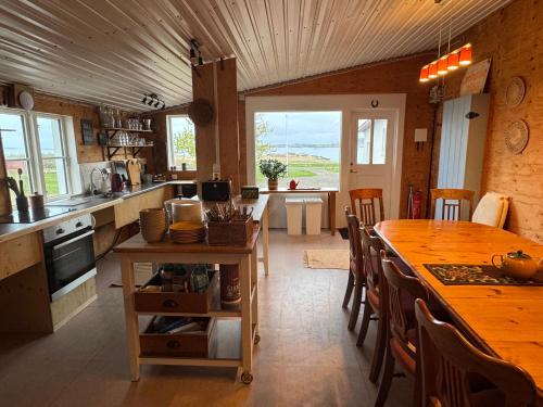 a kitchen with a large wooden table and a dining room at Berunes HI Hostel in Berunes