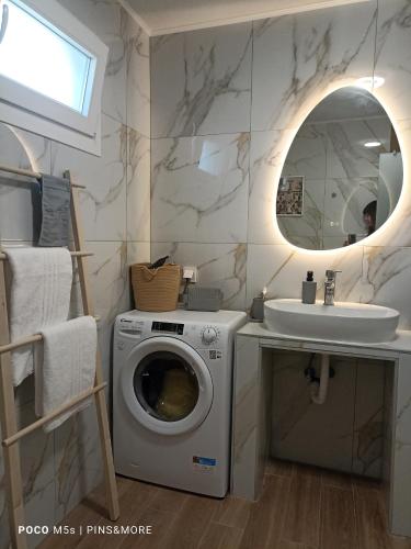 a bathroom with a washing machine and a sink at House Alexandros in Asprovalta