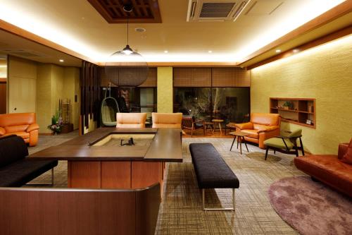 a living room with orange chairs and a couch at Yunokawa Onsen Emi Hakodateya in Hakodate