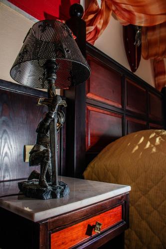 a lamp on a table next to a bed at Castello Di Cavallieri Suites & Spa - Adults Only in Faliraki