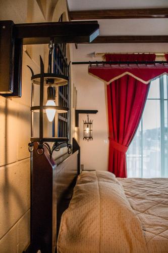 a bedroom with a bed and a red curtain at Castello Di Cavallieri Suites & Spa - Adults Only in Faliraki