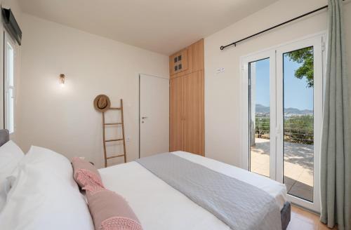 a bedroom with a bed and a large window at ALMA casa in Mardhátion