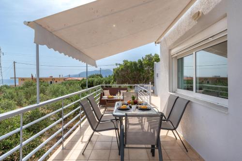 a patio with a table and chairs on a balcony at ALMA casa in Mardhátion