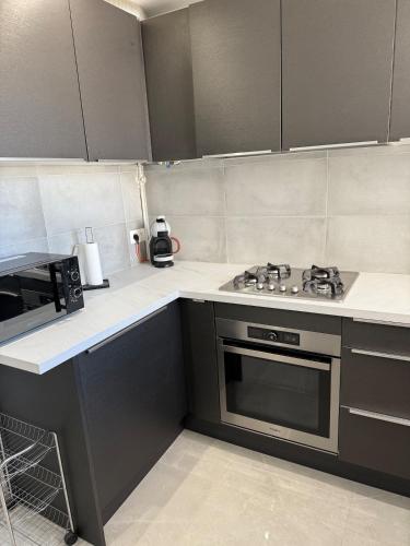 une cuisine avec une cuisinière et un micro-ondes dans l'établissement Le Prestigieux - plage, à Antibes