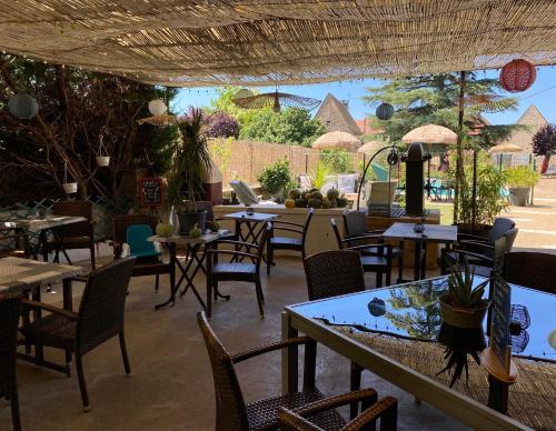 a restaurant with tables and chairs and a patio at Auberge du Relais d'Auniac - Hôtel Bar Restaurant Piscine in Anglars-Nozac