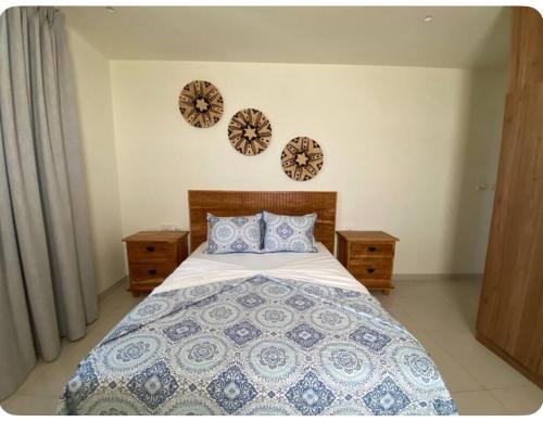 a bedroom with a bed and two clocks on the wall at Fumba Uptown Ocean Front Villa in Fumba Uwandani