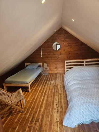- une chambre mansardée avec 2 lits et une chaise dans l'établissement Un chalet à la mer, à Dieppe