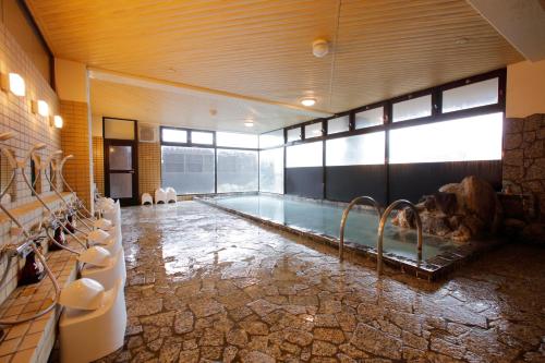 a large bathroom with a swimming pool in a room at Yunokawa Onsen Emi Hakodateya in Hakodate
