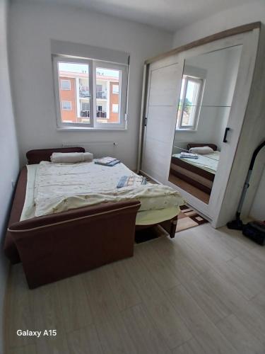 a bedroom with a bed and a large mirror at Apartman Mira in Banja Koviljača