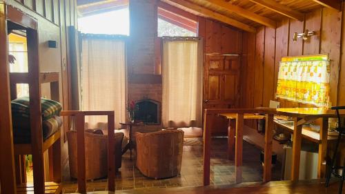a room with a fireplace and two tables and a window at El Toucanet Lodge & Restaurante in El Copey