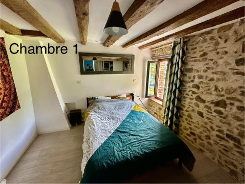 - une chambre avec un lit dans une pièce dotée d'un mur en pierre dans l'établissement Maison au calme, à Saint-Sulpice-le-Dunois