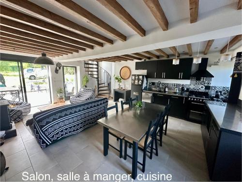 une cuisine et un salon avec une table et un canapé dans l'établissement Maison au calme, à Saint-Sulpice-le-Dunois