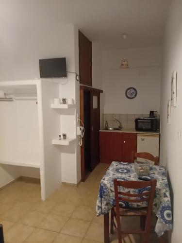 a room with a table and a kitchen with a table and chairs at Mouria Studio B in Kithnos