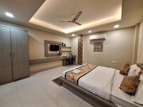 a bedroom with a bed and a ceiling fan at Hotel Mayur Palace in Bhopal
