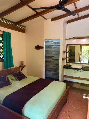 a bedroom with a large bed and a bathroom at Passion Fruit Lodge in Cahuita