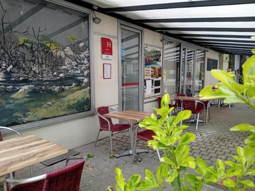 a row of tables and chairs in a restaurant at Hôtel La Gravenne in Thueyts