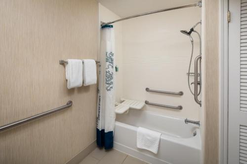 a bathroom with a tub and a shower with towels at Residence Inn Binghamton in Vestal