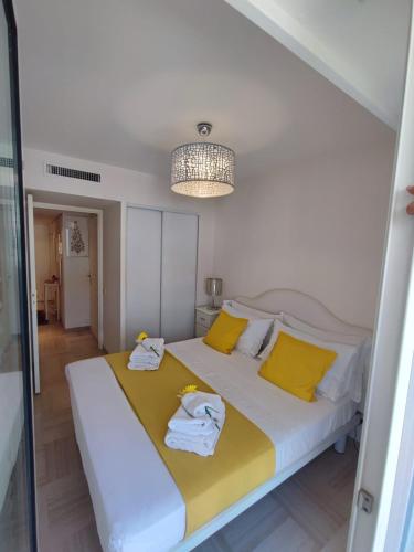 une chambre avec un grand lit avec des oreillers jaunes dans l'établissement Maison Citron, à Menton