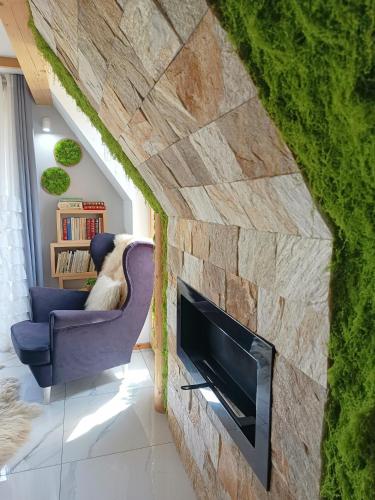 a living room with a stone wall with a fireplace at Lux Houses w DOMKU tylko DWA APARTAMENTYz jacuzzi zewnętrznym in Groń