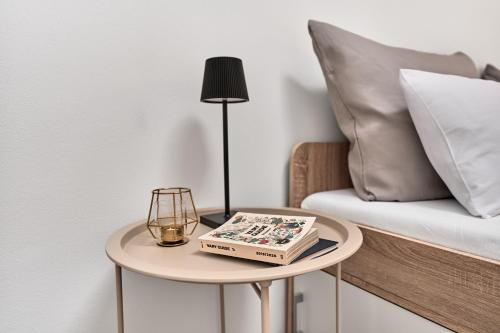 a table with a lamp and a book on it next to a bed at Plavírna in Otovice