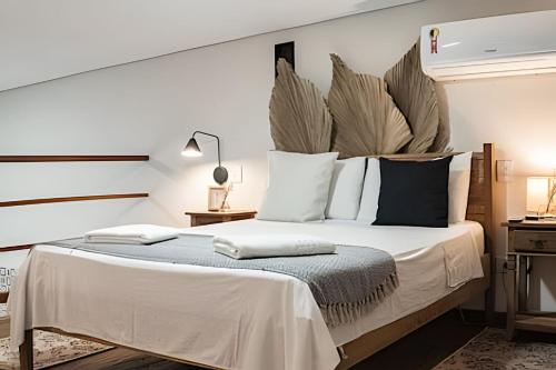 een slaapkamer met een groot bed met een groot hoofdeinde bij Perequê Center in Ilhabela