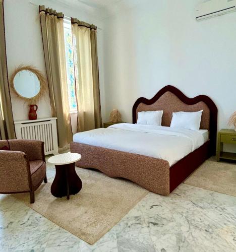 a bedroom with a large bed and a chair at Olivia sidibou in Sidi Bou Saïd