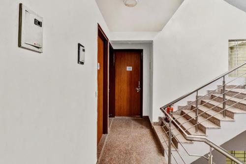 a hallway with stairs and a wooden door at Hotel O South Plaza in New Delhi