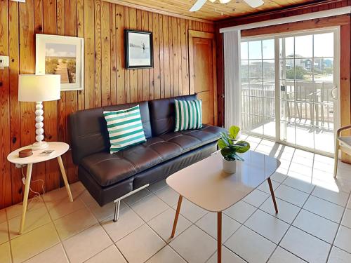 a living room with a leather couch and a table at Sea Glass Suites 3 in Topsail Beach