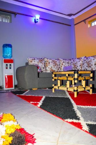 a living room with a couch and a rug at AMANI 'S PLACE in Naivasha