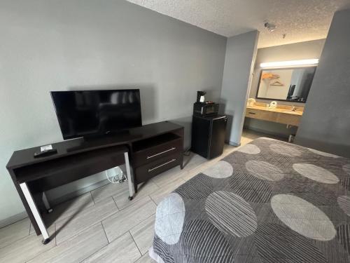 a room with a bed and a flat screen tv at Budget Inn Sanford International Airport in Sanford