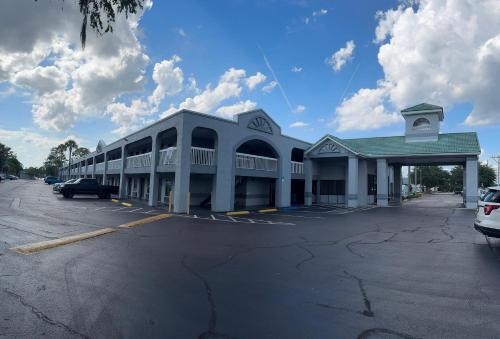 a large white building with a parking lot at Budget Inn Sanford International Airport in Sanford