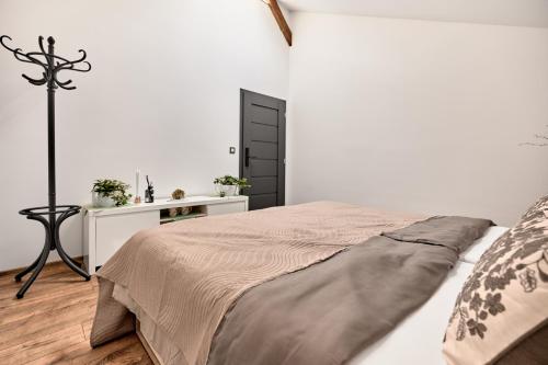a white bedroom with a bed and a table at Plavírna in Otovice