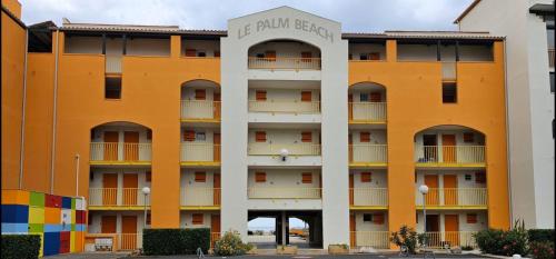 un immeuble d'appartements avec des tons orange et blanc dans l'établissement T2 vue mer Le Barcares, au Barcarès