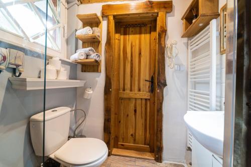 a bathroom with a toilet and a wooden door at Zruby Vila Mária Vysoké Tatry in Otilia