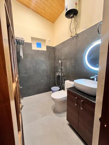 a bathroom with a white toilet and a sink at Sunbird Stay & Cafe in Bhowāli