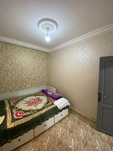 a bedroom with a bed with a flower pattern on the wall at GHOU Appartement TADDART in Agadir