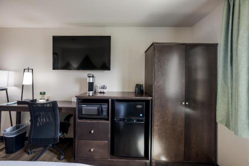 a room with a desk with a microwave and a computer at Mountain Vista Hotel in West Yellowstone
